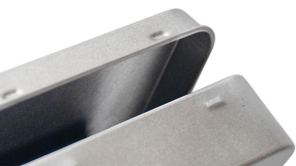 Geöffnete rechteckige, silberne Metalldose mit Deckel auf weißem Hintergrund